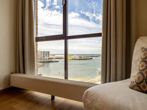 A room with a large window, a bed, and a radiator. - Luxury Apartment With a View (The Hague)