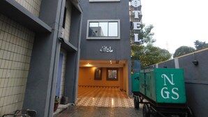 L’entrée d’un hôtel, avec un sol carrelé, une enseigne et un panneau vert portant des lettres.