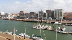 A marina with various boats docked, surrounded by buildings and a clear sky. - Attractive Apartment in Den Haag with Balcony near Beach (The Hague)