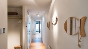 Un couloir doté d’un plancher en bois, d’un radiateur et de luminaires fixés au mur.