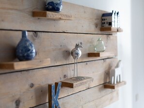 A wooden wall with shelves displaying various decorative items. - Apartment in Netherlands With Marina View (The Hague)