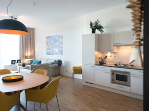 Een moderne keuken met witte kasten, een gasfornuis en een magnetron.