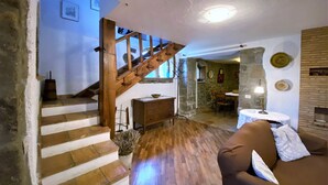 Un interior rústico con una escalera de madera, un comedor y un rincón de estar acogedor.