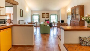 A spacious living area with a dining table, a sofa, and a cabinet.