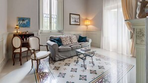 A well-lit living room with a sofa, chairs, a coffee table, and a fireplace. - Holiday Home in Toscana With Pool (Larciano)