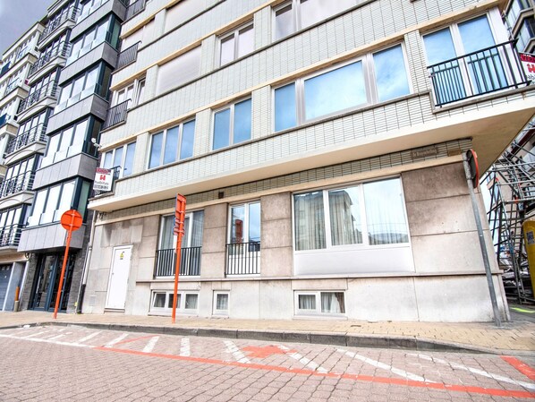 Un edificio de varios pisos con fachada plana, ventanas amplias y balcones.