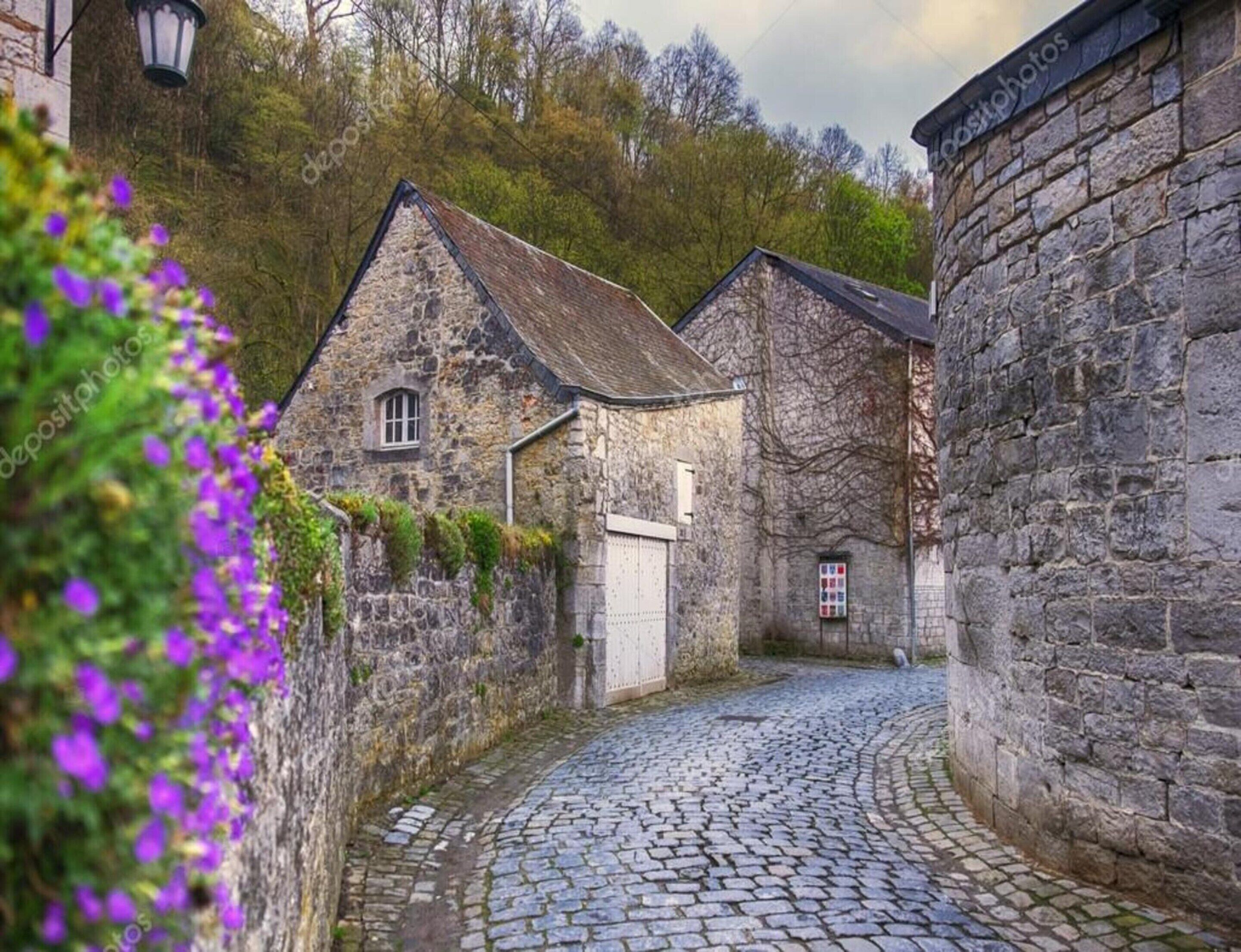 A cobblestone street with stone buildings, a white door, and a small window.