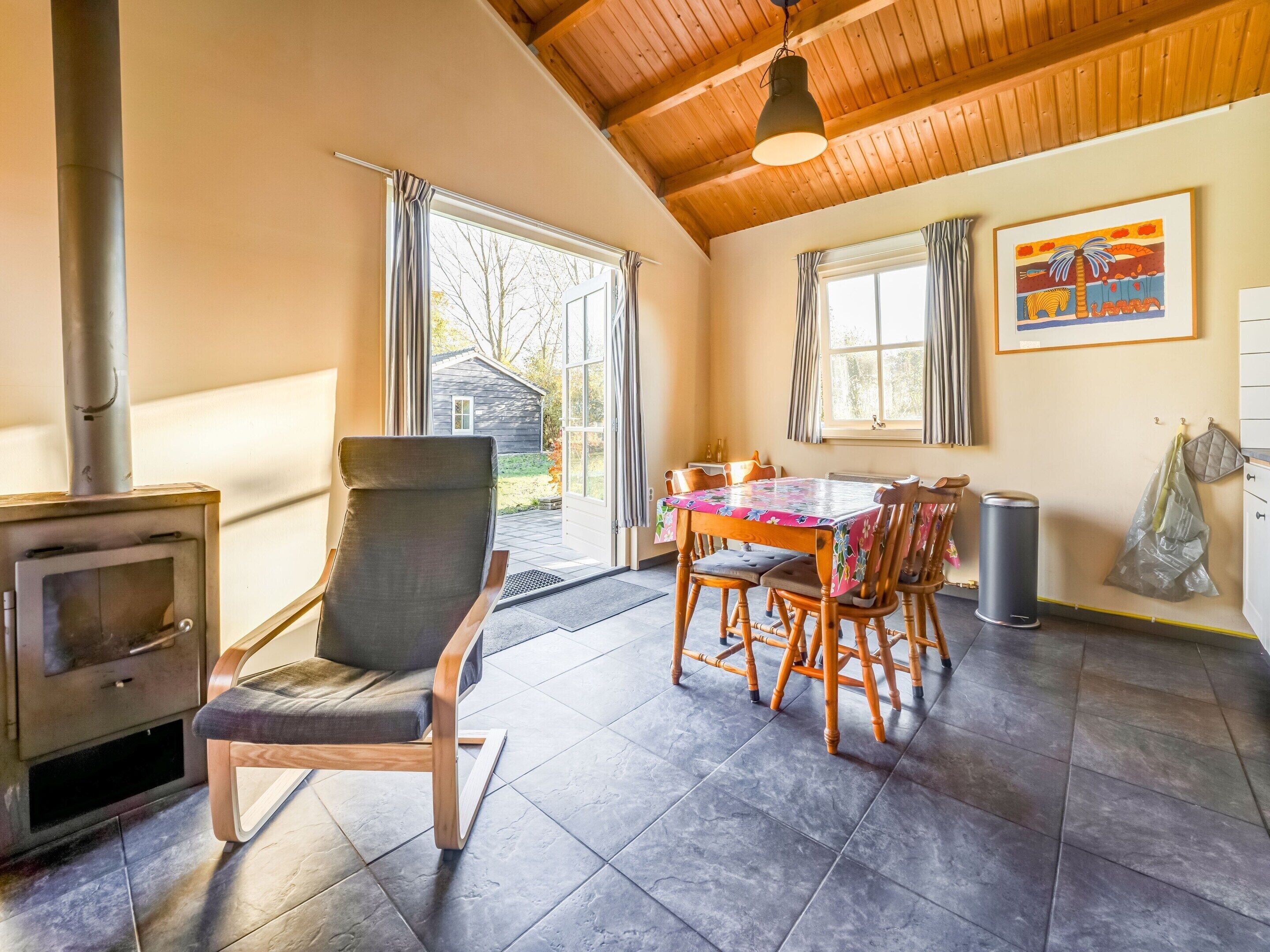 Een gezellige kamer met een open haard, een houten eettafel en stoelen.