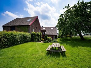 Een bakstenen huis met schuin dak en klein raam.