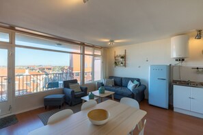 A modern apartment with a balcony, a dining area, a kitchen, and a living room. - Romantic Coastal Retreat With Scenic Balcony (Zoutelande)