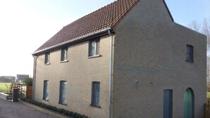 Un bâtiment à deux étages, doté d’un toit en pente et d’une façade en briques.