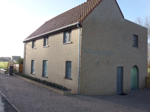 A two-story building with a sloped roof and a brick facade.