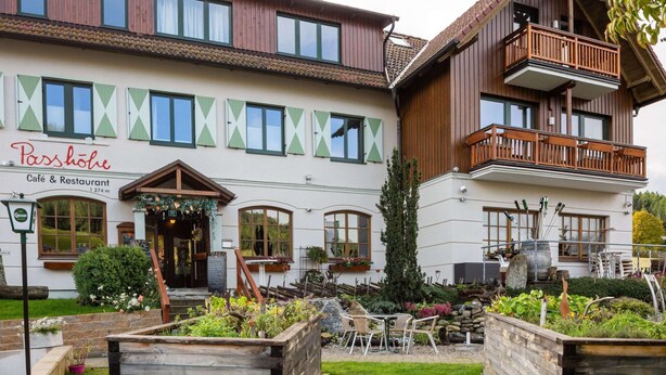 A building with a sign reading "Passhöhe Café & Restaurant" and a balcony with outdoor seating. - Apartment in Hohentauern Near Ski Lift (Hohentauern)