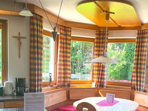 Cozy room with a central table, cushioned seating, and a wooden cross on the wall.
