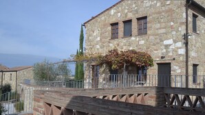 Un bâtiment en pierre doté d’un balcon, d’une rambarde en métal et offrant une vue sur la mer.