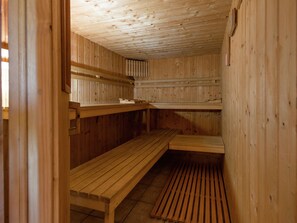 Una sauna con panche di legno e pavimento a listelli.