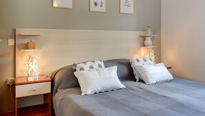 A neatly arranged bedroom with a bed, bedside tables, and wall-mounted shelves. - Apartment in Medulin Near the Beach (Medulin)