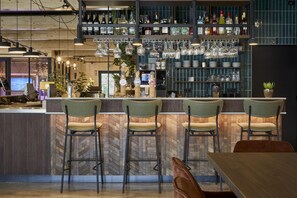 A bar area with a herringbone wood floor, bar stools, and a variety of bottles and glasses on shelves. - Comfy Bungalow near Bosland Nature Reserve (Hechtel-Eksel)