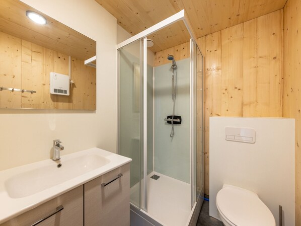A modern bathroom with a glass-enclosed shower, a white sink, and a toilet. - Comfy Bungalow near Bosland Nature Reserve (Hechtel-Eksel)