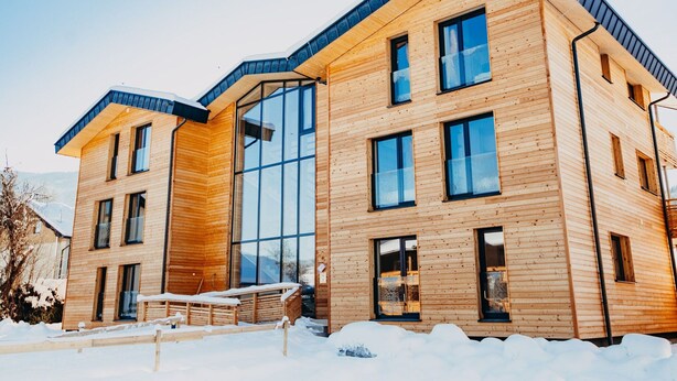 A modern wooden building with large windows and a sloped roof. - Luxurious Apartment in St Georgen am Kreischberg With Sauna (Sankt Georgen am Kreischberg)