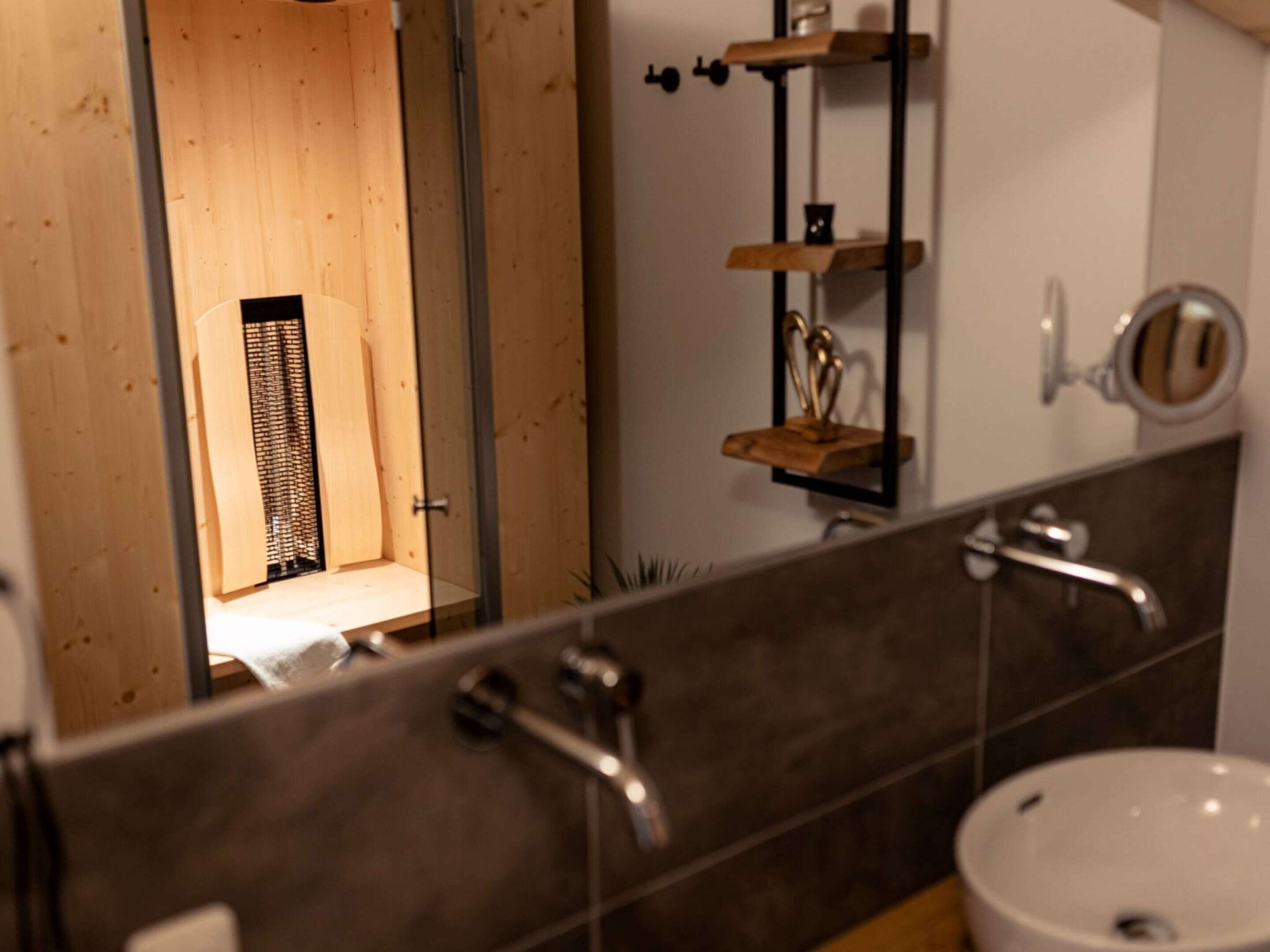 Une salle de bain avec un meuble-lavabo en bois, un miroir, un lavabo et un porte-serviettes.
