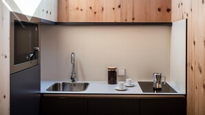 Una cucina moderna con forno integrato, lavello in acciaio inossidabile e macchina per il caffè.