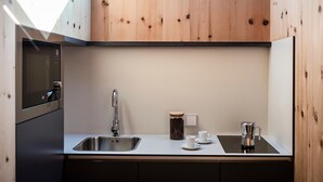 A compact kitchen with a sink, a coffee maker, and a jar of coffee. - Flat in Alpe di Siusi With Wellness Area (Castelrotto)
