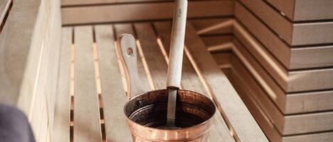 A copper mug with a wooden handle on a wooden bench.