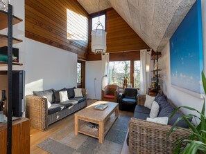 A spacious living room with a high ceiling, wooden beams, and large windows. - Apartment in Veere Near Lake Veerse Marina (Veere)