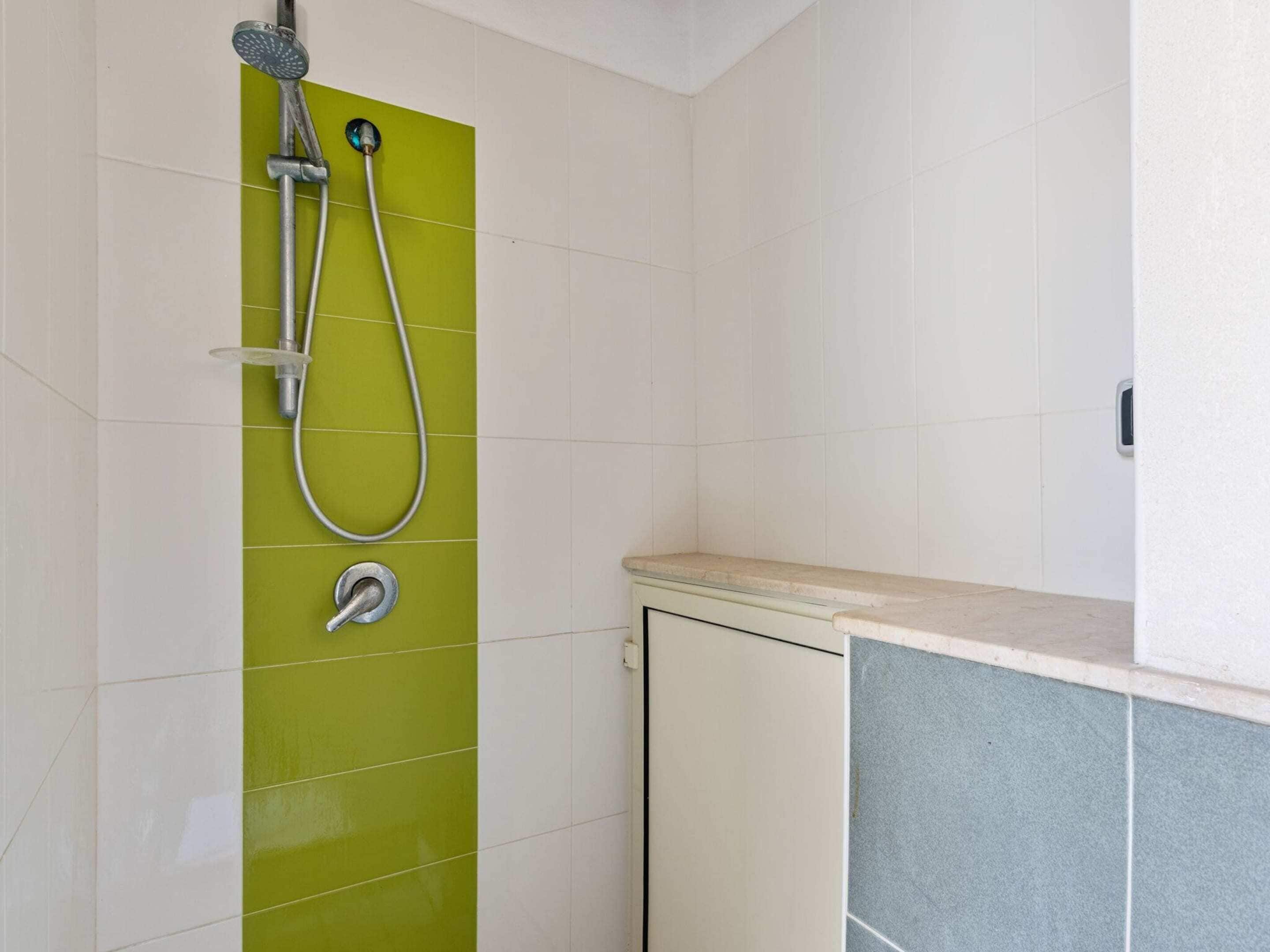 A bathroom with a shower, a toilet, and a sink.