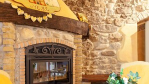 A stone fireplace with a decorative arch, a brick surround, and a wooden mantel. - Belvilla by OYO Il Nido (Castelfranco Piandisco)