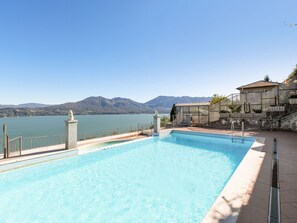 Una piscina con vistas a montañas y un lago.