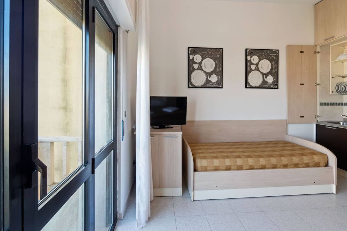 Una camera da letto con un letto, una TV e due opere d'arte a parete.
