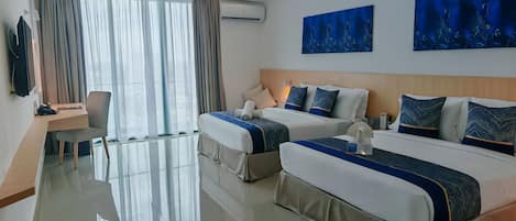 Habitación de hotel con dos camas, un escritorio, una silla y obras de arte en las paredes.