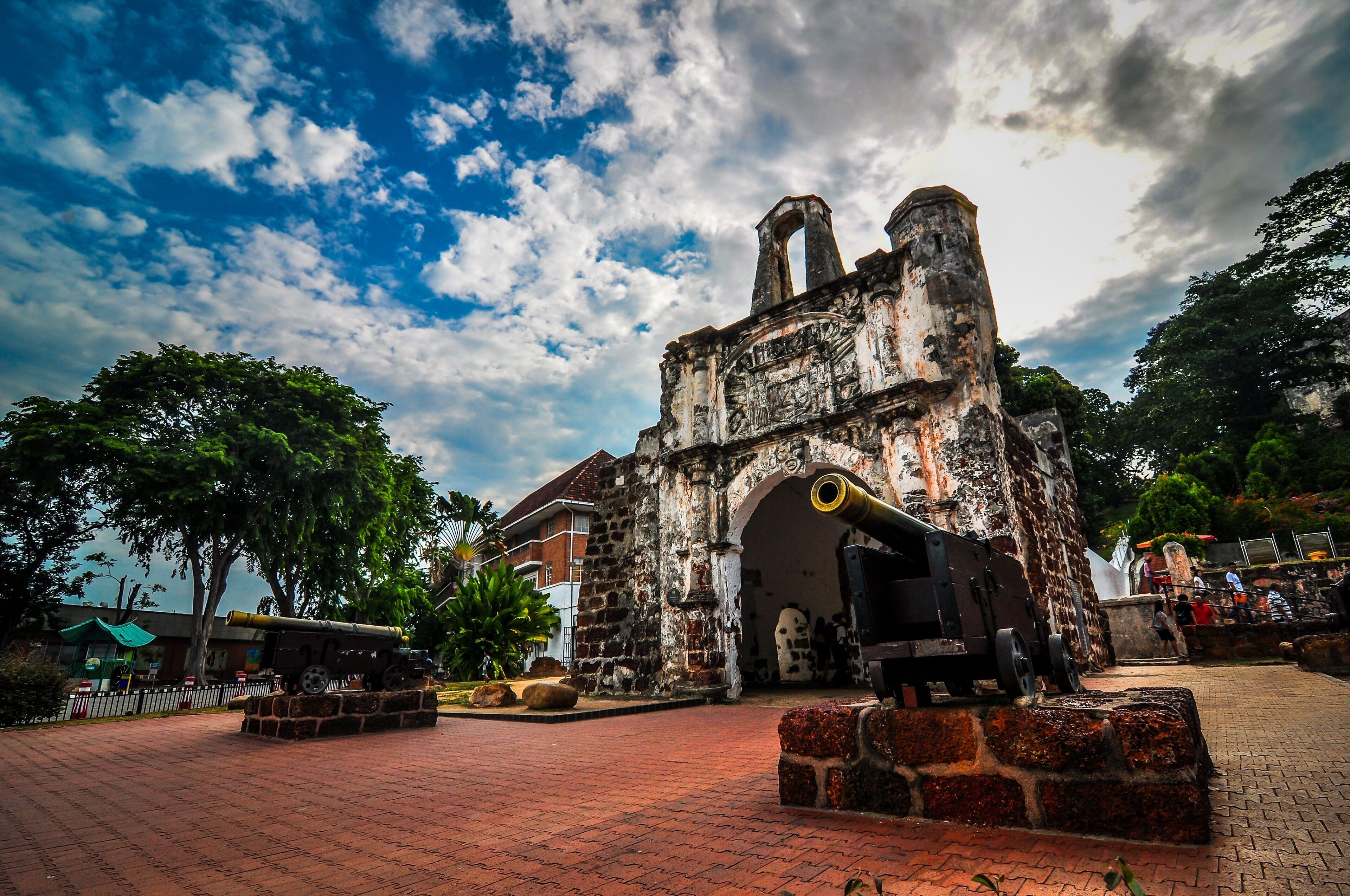 An old stone building with a cannon in front.