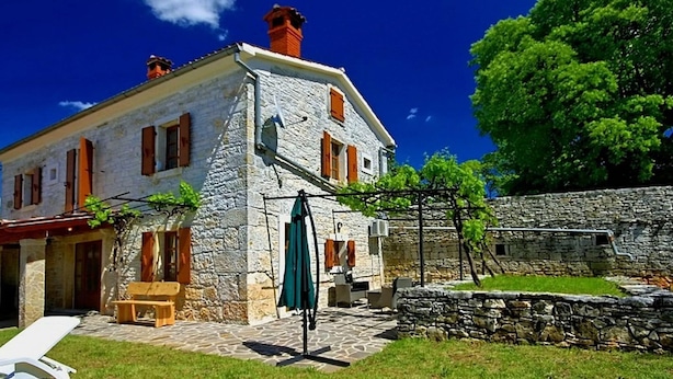 Un bâtiment en pierre doté d’un balcon et d’un espace extérieur aménagé pour s’asseoir.