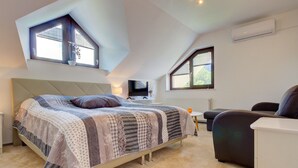 A bedroom with a bed, a TV, a desk, and a chair. - Charming Apartment in Bled Near Lake (Bled)