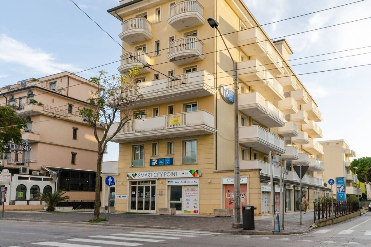 A multi-story hotel with balconies, a Smart City Point sign, and a pedestrian crossing.