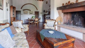 A traditional living room with a fireplace, wooden furniture, and a dining area. - Tuscan Farmhouse in Peccioli with Swimming Pool near Lakes (Peccioli)