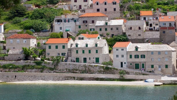 A coastal town with stone buildings, a sandy beach, and a calm sea. - Beautiful Holiday Home on the Island Brac, With the Sea and a Small Beach in Front of the Door (Pucisca)