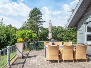 An outdoor patio with wicker furniture, a table, and a grill. - 6 Person Holiday Home in Skovgårde Allingåbro (Allingåbro)