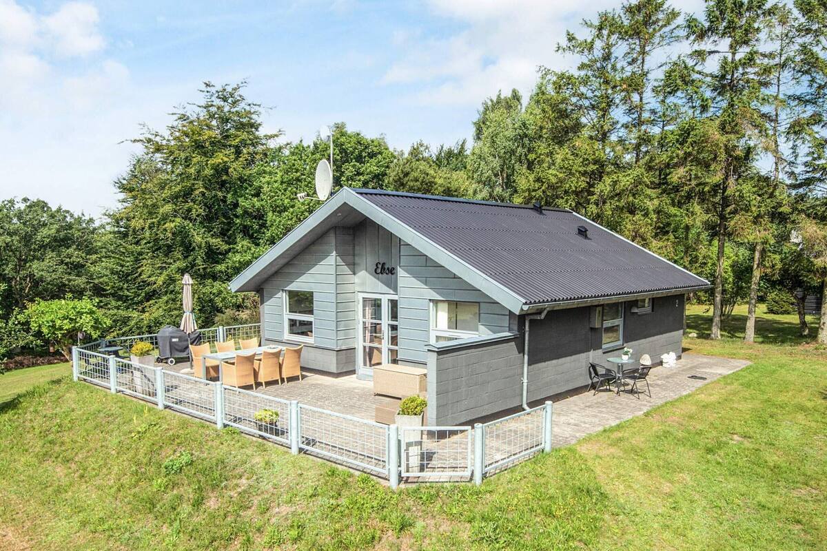 Een tweelaags huis met een overdekte patio, een omheinde tuin en een schotelantenne.