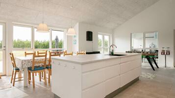 Una cocina amplia con una isla grande, sillas de madera y una mesa de comedor.