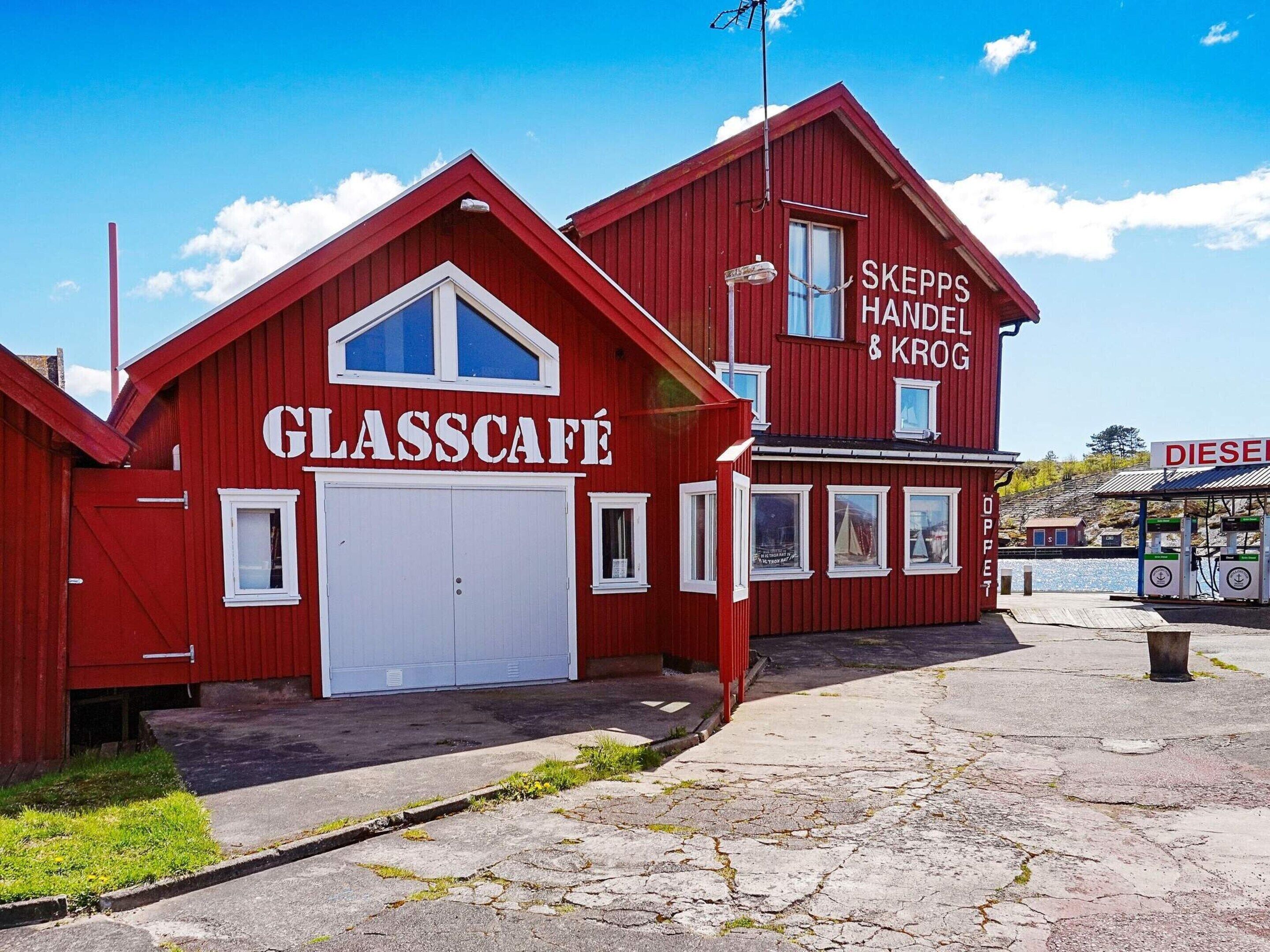 Ein rotes Gebäude mit einer großen Garagentür und einem Schild, auf dem 'GLASSCAFE' steht.