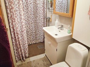 Ein Badezimmer mit Duschvorhang, Waschbecken und Toilette.