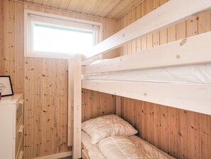 A bunk bed room with wooden walls, a window, and a framed picture on a small table. - Holiday Home in Haderslev (Haderslev)