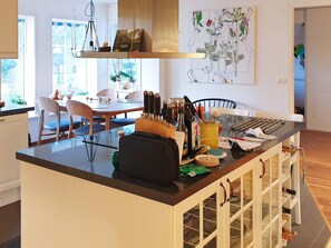 A modern kitchen with a central island, dining area, and a large window. - Holiday Home in VÃ¤tÃ¶ (Vätö)