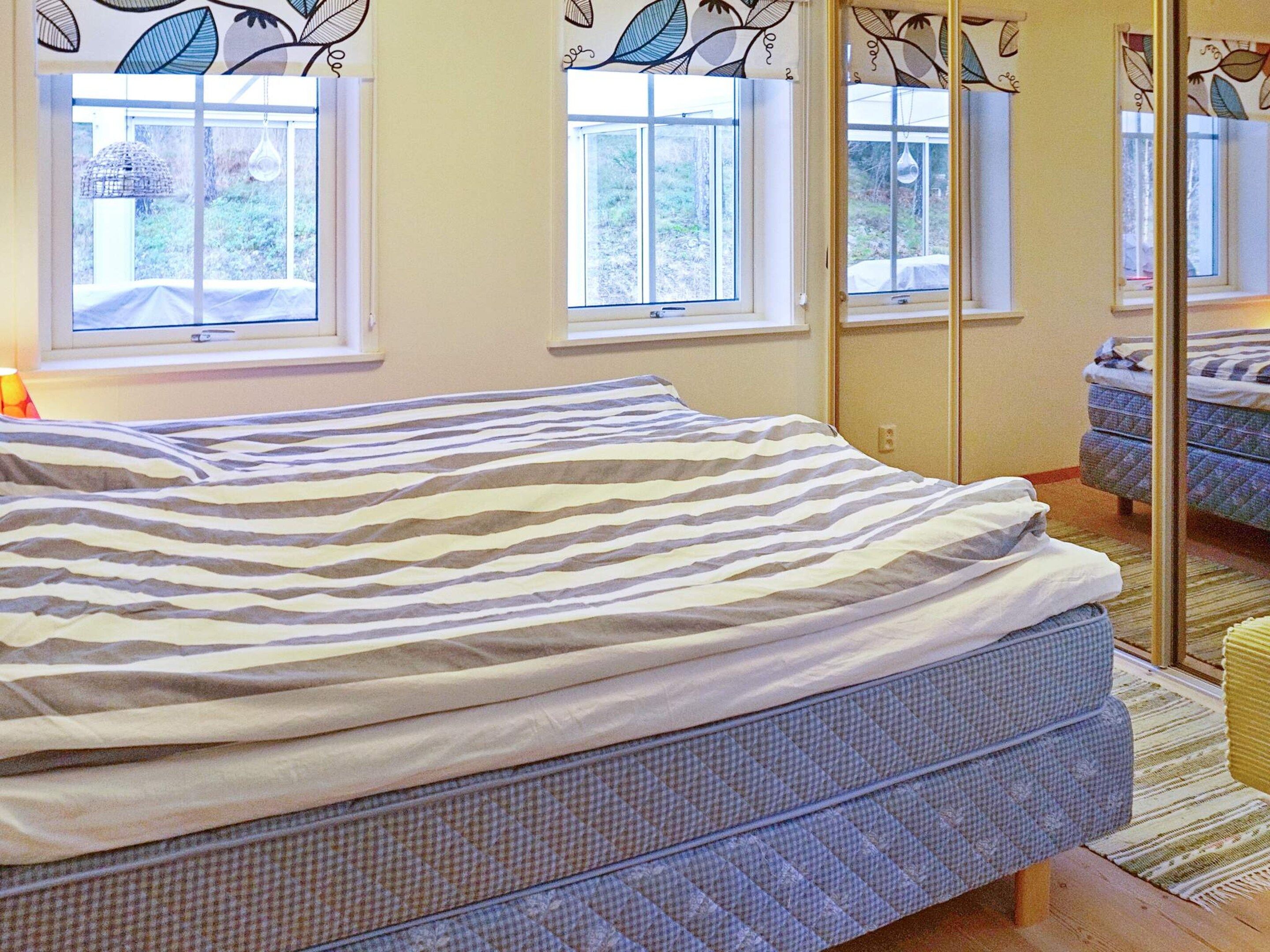 A bedroom with a bed, a window, and a mirror.