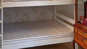 A bunk bed with a patterned mattress and a decorative headboard.
