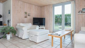 A modern living room with a white sofa, a coffee table, and a television. - 8 Person Holiday Home in Borkop (Borkop)